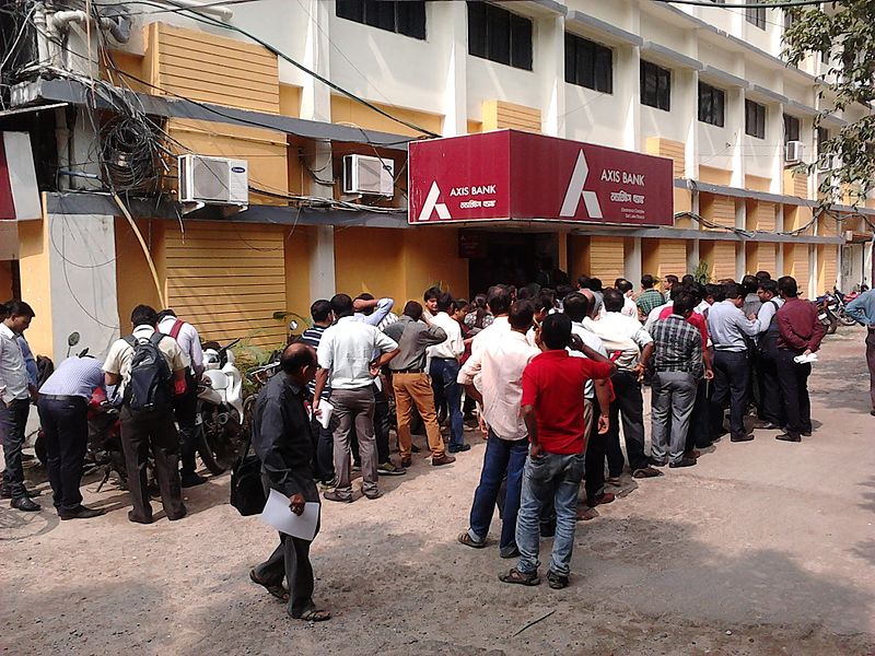 <u>Query</u>: A large group of people waiting outside to enter a building so as to engage in financial matters<br>
      <u>Named Entity</u>: Axis Bank