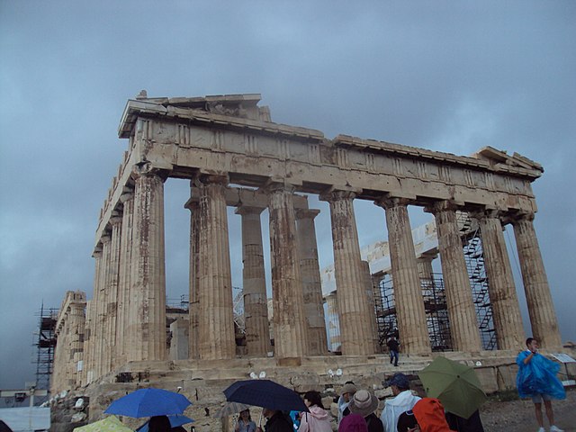 <u>Query</u>: Visitors standing in rain admiring a temple dedicated to the Greece goddess Athena<br>
      <u>Named Entity</u>: Parthenon